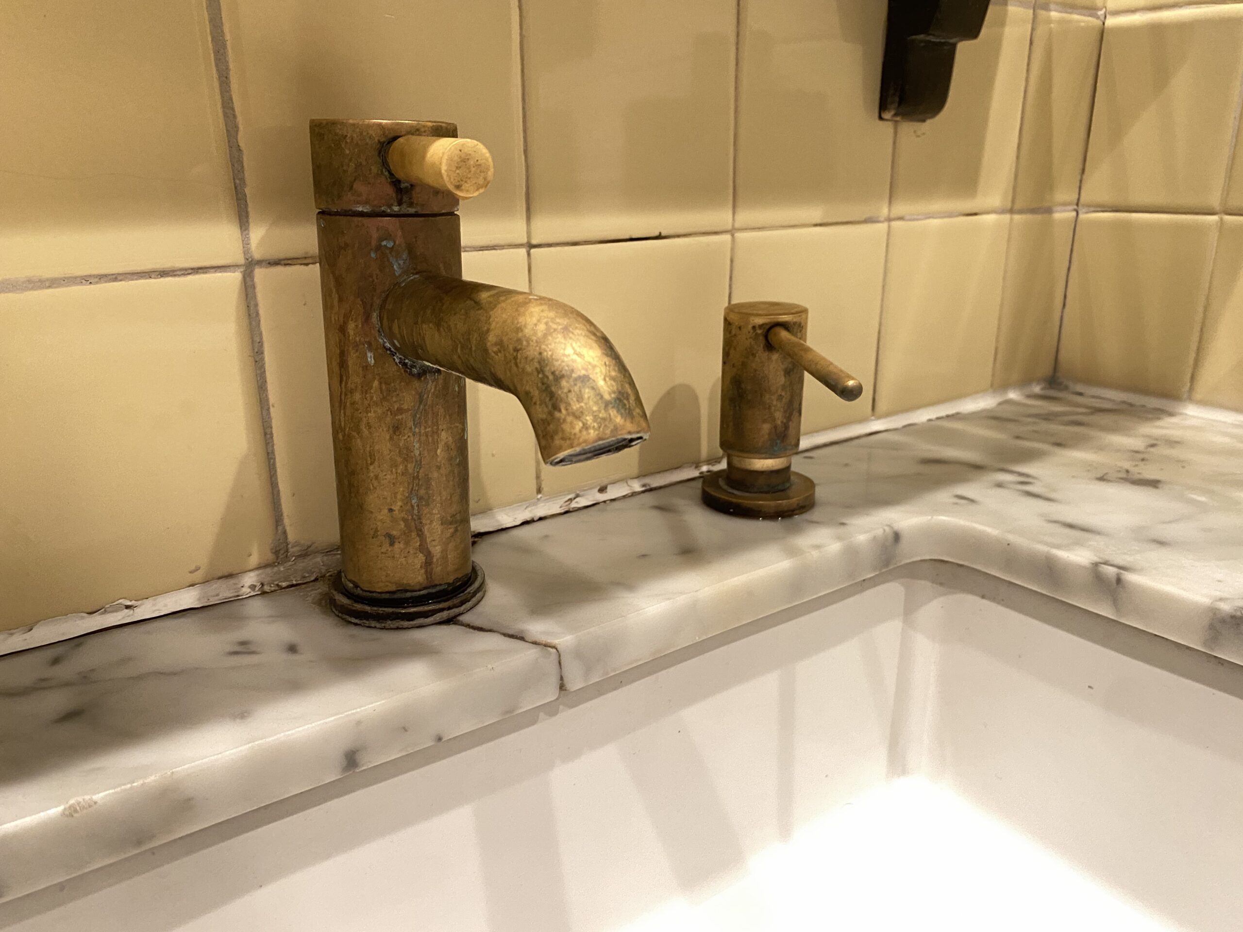 Single hole bathroom faucet and soap dispenser in unlacquered brass